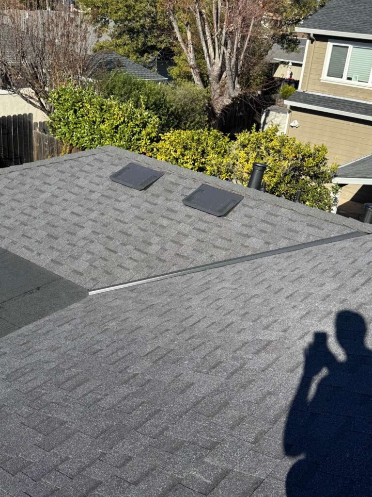 New asphalt shingle roof with installed attic vents on a residential home.